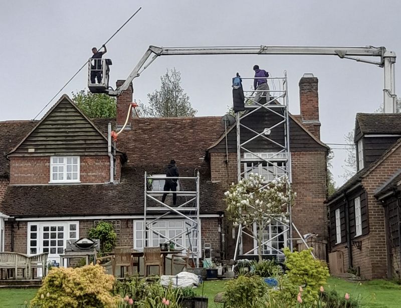 The Moss Cleaners using cherry picker and scaffolding to clean roof safely and professionally in Oxted, Surrey